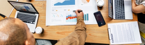 People at desk with marketing papers.