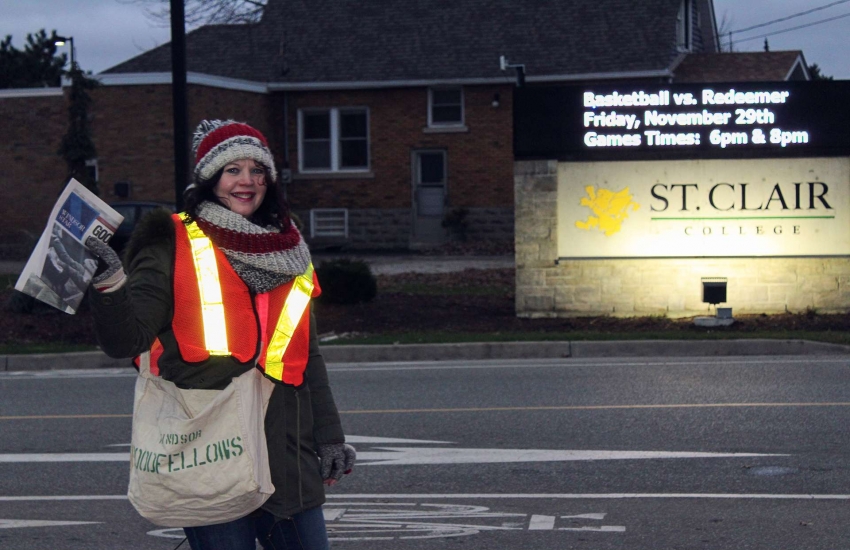 St. Clair College President Patti France handing out Windsor Goodfellows newspapers.