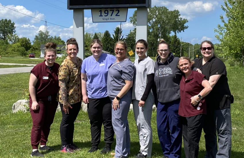 Vet Tech group in front of clinic sign