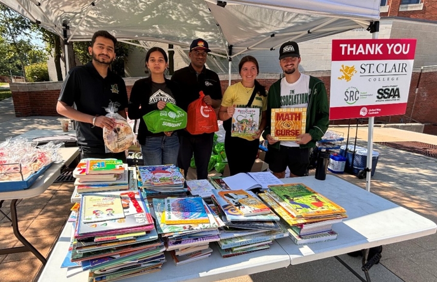 Volunteers posing at table with books