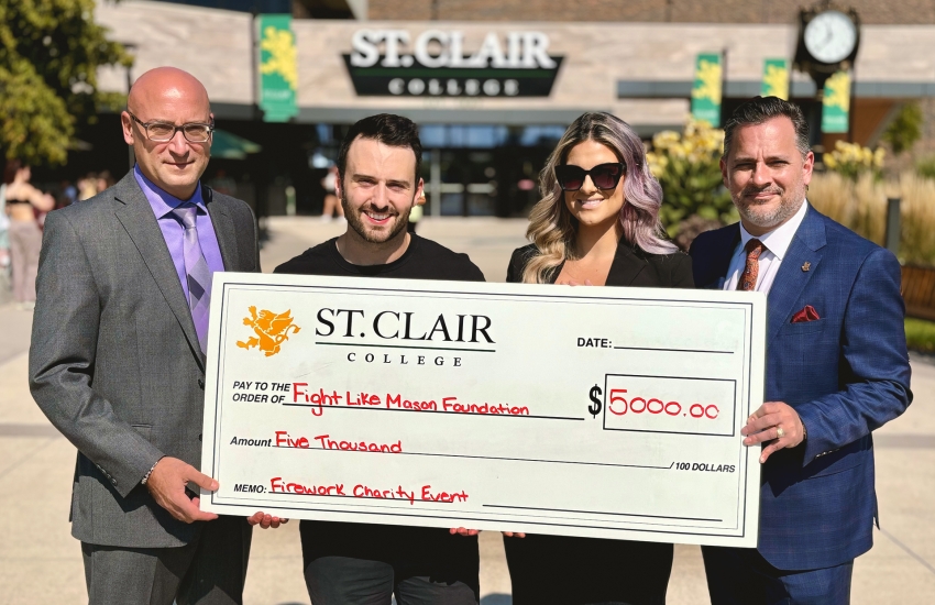 Joe D'Angela, the Senior Director of St. Clair College Centre for the Arts, Iain Macri, Chantelle Bacon, and St. Clair College President Michael Silvaggi pose with a cheque