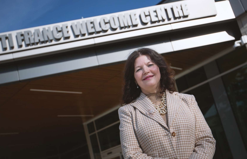 Former College President Patti France stands in front of the Patti France Welcome Centre