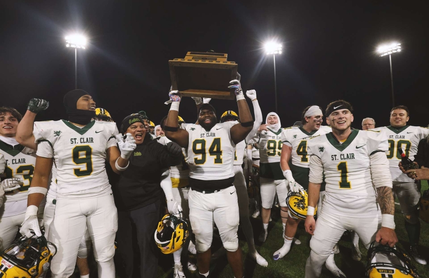 Members of the Saints Men's Football team hoist the OFC Championship tophy