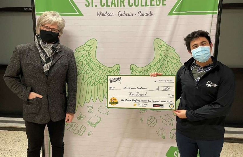 Jeff Burrows presents SRC president Jorge Gutierrez Calzada with a cheque for the student food bank.