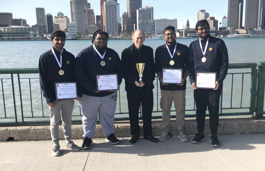 First place winners in front of Detroit river with coach