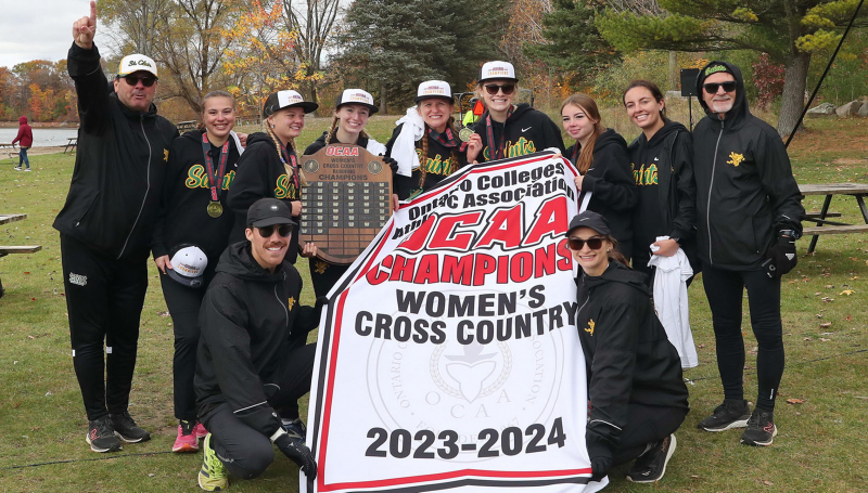 Womens Cross Country team with champion banner