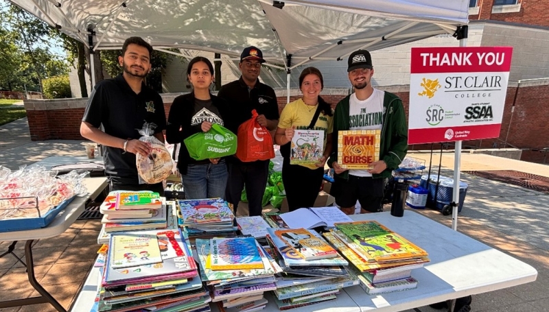 Volunteers posing at table with books