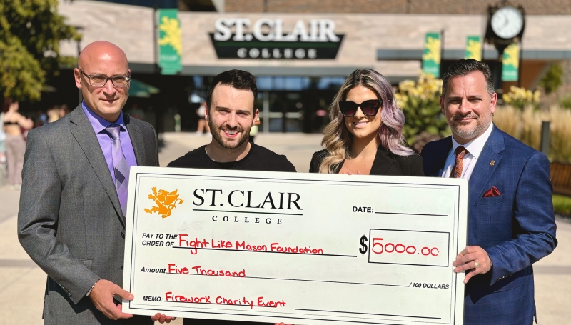 Joe D'Angela, the Senior Director of St. Clair College Centre for the Arts, Iain Macri, Chantelle Bacon, and St. Clair College President Michael Silvaggi pose with a cheque