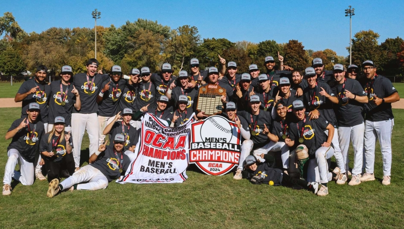 Saints men's baseball team celebrating while holding banners