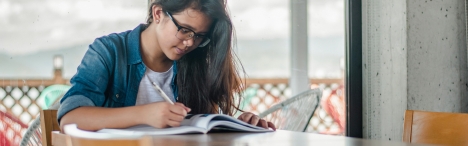 Female student writing in notebook.