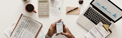 Business man on phone with computer and business papers on desk.