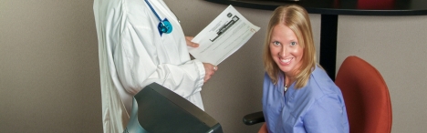Woman behind computer smiling.